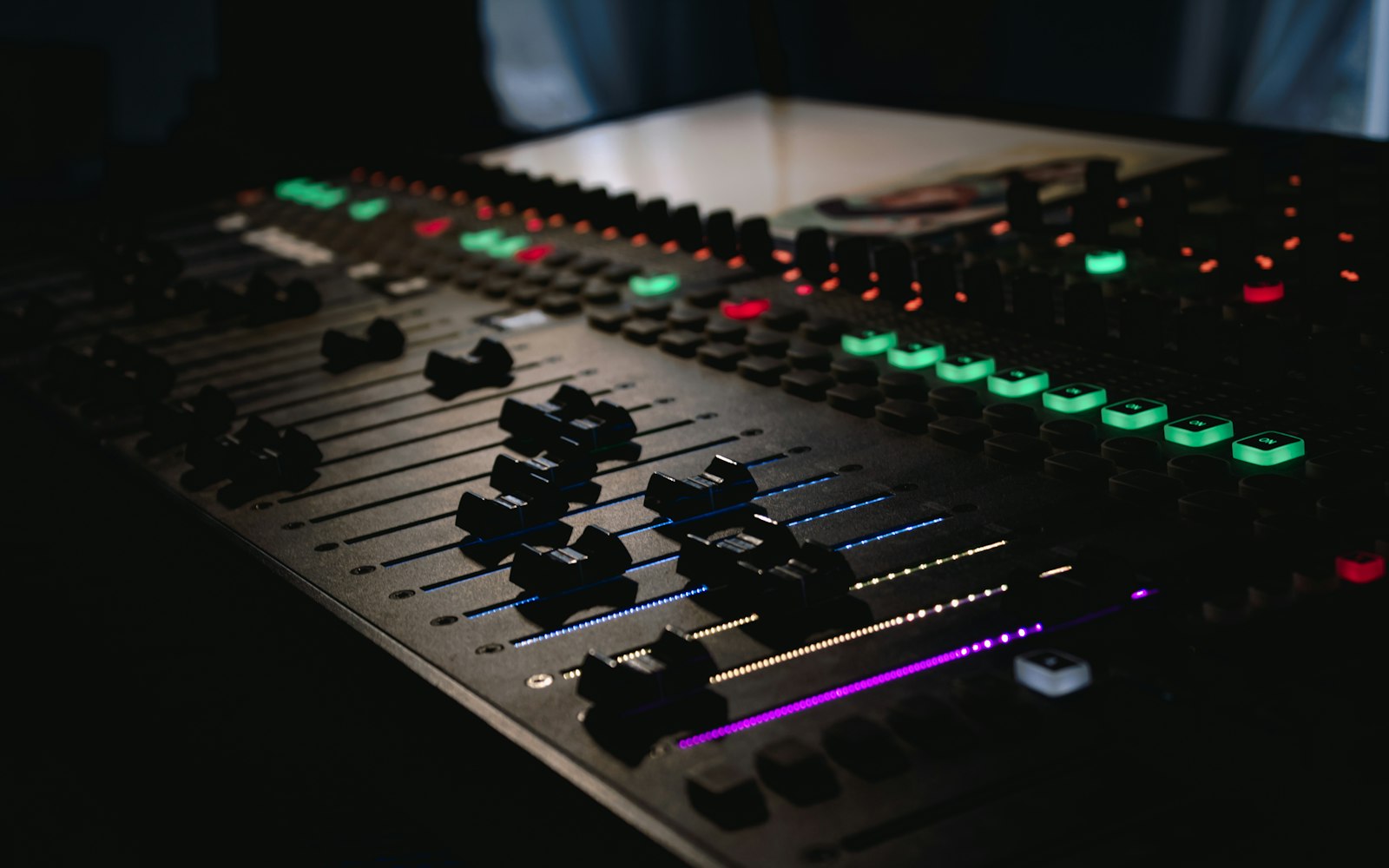 Estudante de produção musical trabalhando em mesa de áudio com fones de ouvido em estúdio