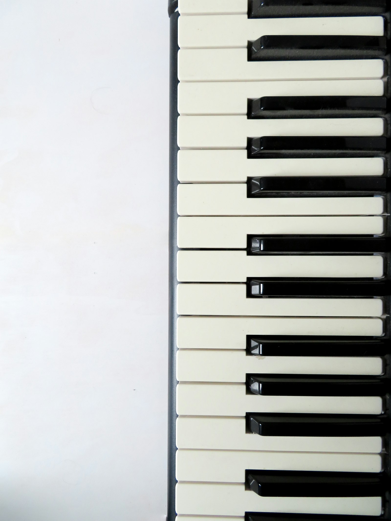 Estudante de música sentado ao piano em sala de aula, com partituras abertas na estante